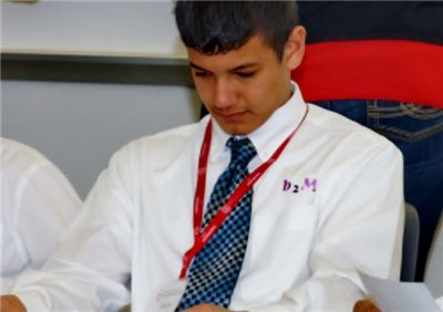 Young man in a white dress shirt and tie focused on his work