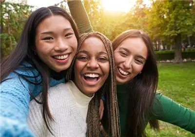 Three young women smiling together outdoors